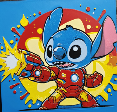 Framed 3D layered art piece featuring an action-packed illustration of a cute blue alien character wearing high-tech red and gold robotic armor, firing a bright energy blast from its palm repulsor against a dynamic comic-book style background with red and yellow paint splatters.