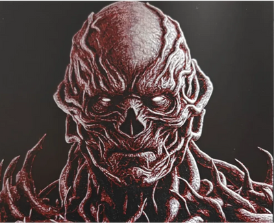 Framed 3D layered art piece featuring a detailed portrait of a sinister, fleshy sci-fi humanoid monster with exposed muscular tendrils and vines covering its body against a dark background.