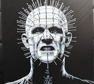 Framed 3D layered art piece featuring a striking black and white portrait of a pale horror character with a clean grid pattern carved into his head and metallic pins inserted at every intersection.