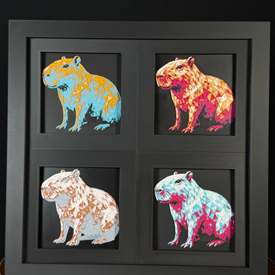 Four-panel framed geometric capybara layered 3D art set showing the capybara design in Heritage, Crimson Ice, Royal Gold, and Teal Orange color palettes inside a charcoal matte four-pack display frame.