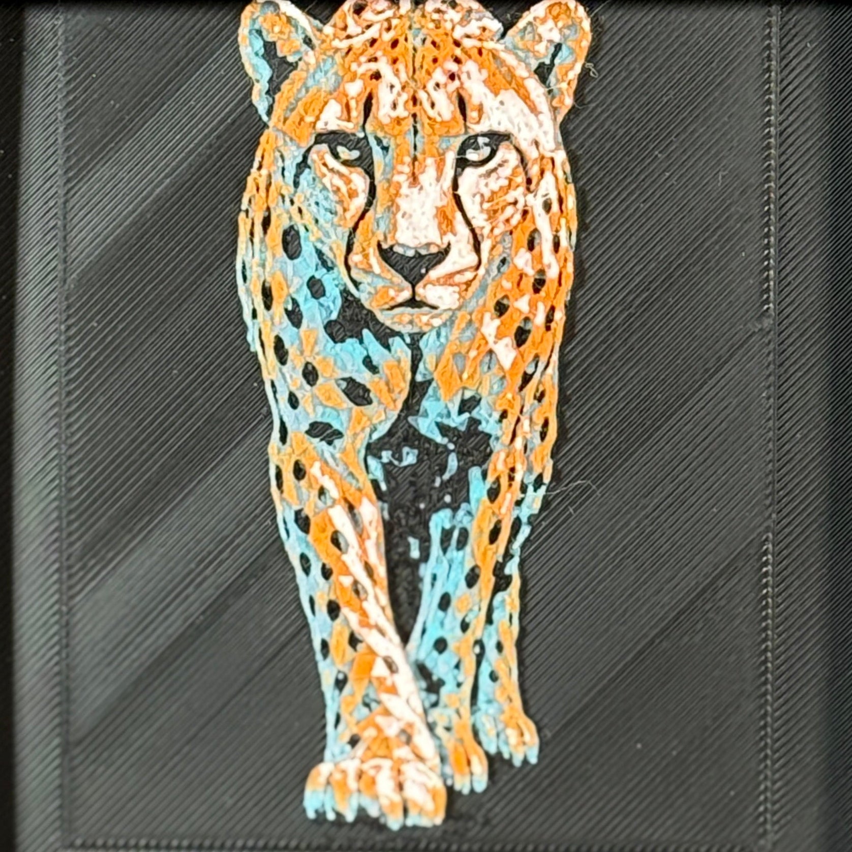 Geometric cheetah framed layered 3D art in Teal Orange color palette, featuring a standing cheetah with turquoise, orange, black, and white layered details inside a charcoal matte display frame.