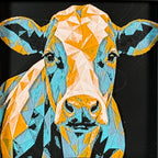 Geometric cow framed layered 3D art in Teal Orange color palette, featuring a bold cow portrait with turquoise, orange, black, and white layered details inside a charcoal matte display frame.