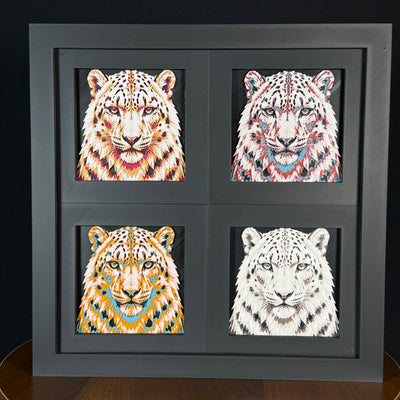 Four-panel framed geometric snow leopard layered art set showing the same front-facing leopard portrait in four WTX3D color palettes, arranged in a charcoal black 2x2 frame with sharp facial detail, spotted fur texture, and high-contrast layered color.
