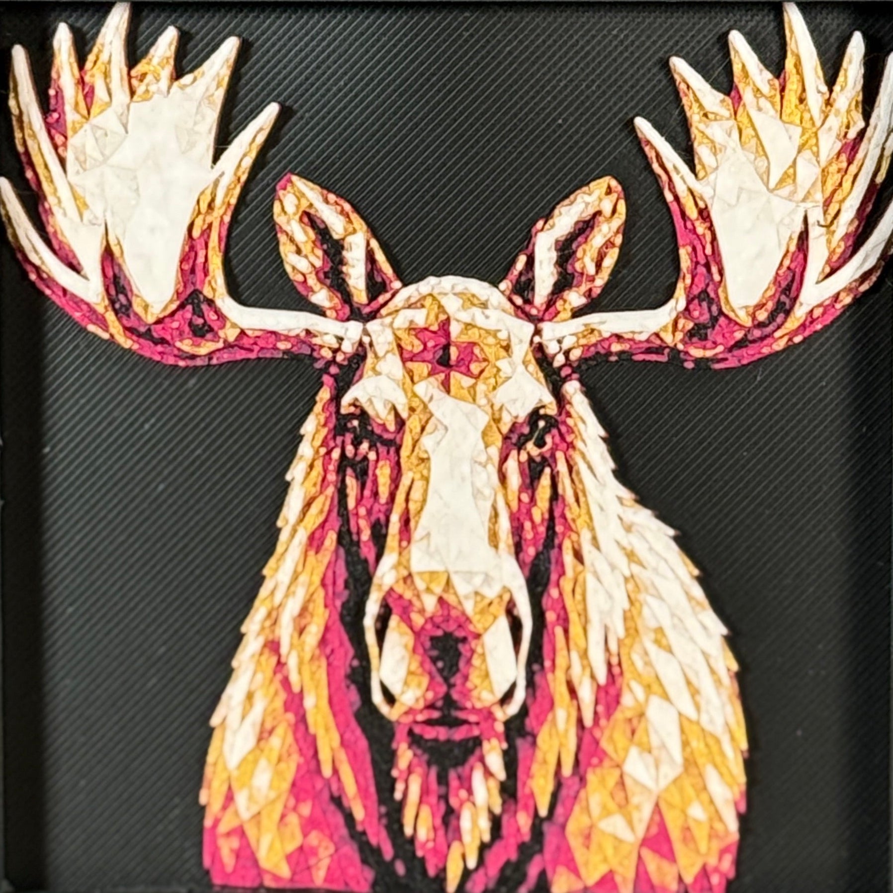 Geometric moose framed layered 3D art in Crimson Ice color palette, featuring a moose portrait with cyan, red, magenta, black, and white layered details inside a charcoal matte display frame.
