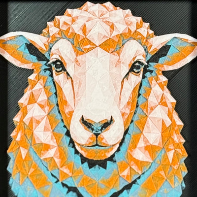 Geometric sheep framed layered 3D art in Teal Orange color palette, featuring a sheep portrait with turquoise, orange, black, and white layered details inside a charcoal matte display frame.