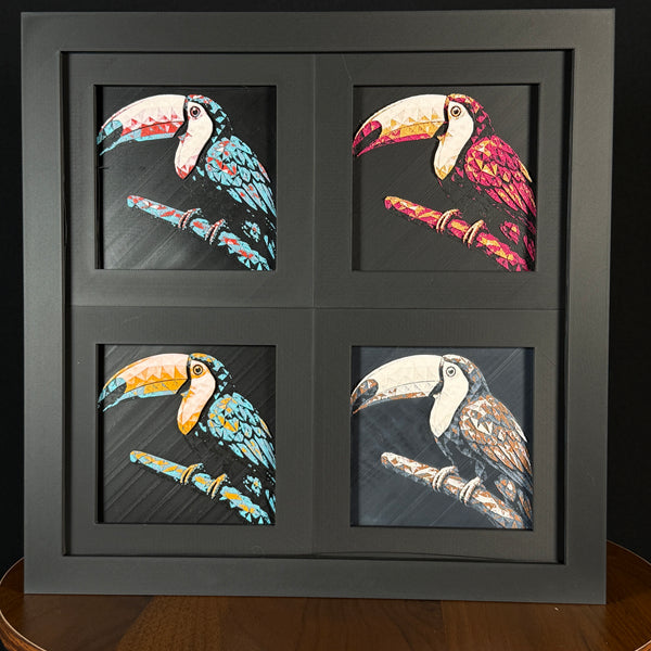 Four-panel framed geometric toucan layered 3D art set showing the toucan design in Heritage, Crimson Ice, Royal Gold, and Teal Orange color palettes inside a charcoal matte four-pack display frame.