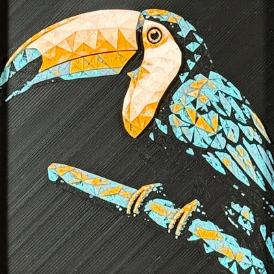 Geometric toucan framed layered 3D art in Teal Orange color palette, featuring a toucan portrait with turquoise, orange, black, and white layered details inside a charcoal matte display frame.
