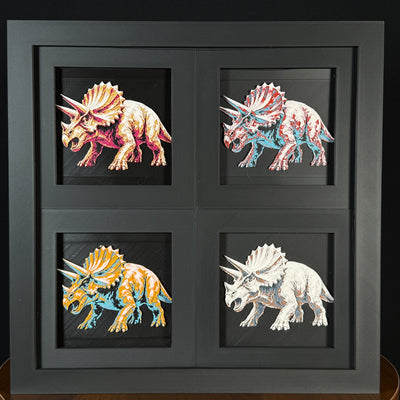 Four-panel framed geometric Triceratops layered 3D art set showing the Triceratops design in Heritage, Crimson Ice, Royal Gold, and Teal Orange color palettes inside a charcoal matte four-pack display frame.
