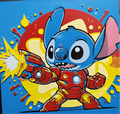 Framed 3D layered art piece featuring an action-packed illustration of a cute blue alien character wearing high-tech red and gold robotic armor, firing a bright energy blast from its palm repulsor against a dynamic comic-book style background with red and yellow paint splatters.