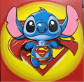 Framed 3D layered art piece featuring an adorable illustration of a cute blue alien character dressed as a classic comic book flying superhero, complete with a flowing red cape, yellow belt, and a red and yellow chest emblem, set against a large matching hero shield background.