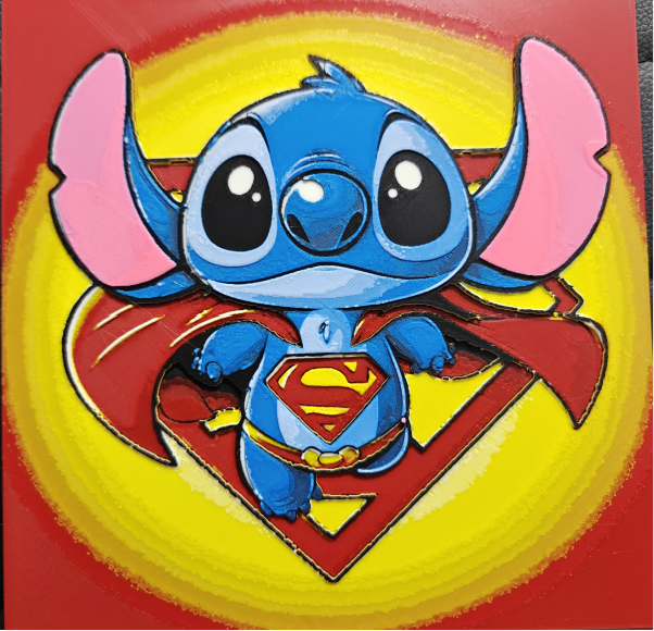 Framed 3D layered art piece featuring an adorable illustration of a cute blue alien character dressed as a classic comic book flying superhero, complete with a flowing red cape, yellow belt, and a red and yellow chest emblem, set against a large matching hero shield background.