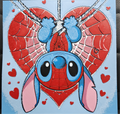 Framed 3D layered art piece featuring an adorable illustration of a cute blue alien character dressed in a red, web-patterned comic hero mask and torso, hanging upside down from a silver thread in front of a large red heart with web details, surrounded by smaller red hearts against a light blue background.