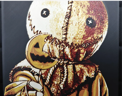 Framed 3D layered art piece featuring a creepy character wearing a burlap sack mask with mismatched button eyes and a stitched grin, holding an orange pumpkin lollipop.