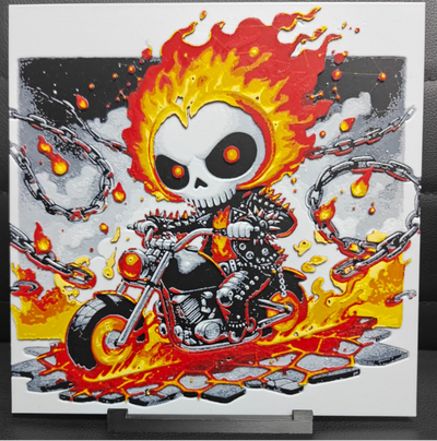 Framed 3D layered art piece featuring a fun cartoon illustration of a chibi-style skeleton rider with a flaming head riding a mechanical chopper motorcycle surrounded by bright orange flames.