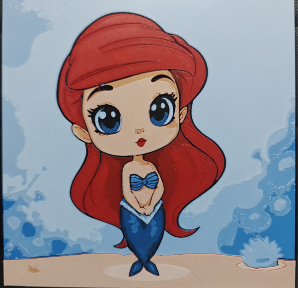 Framed 3D layered art piece featuring an adorable chibi illustration of a mermaid princess character with long flowing bright red hair, a blue seashell top, and a matching blue tail, standing on a sandy floor against a soft blue ocean background.