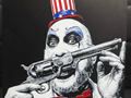 Framed 3D layered art piece featuring a detailed portrait of a creepy horror movie killer clown with smeared white and black face paint, baring his teeth while wearing a patriotic red, white, and blue stars-and-stripes top hat.
