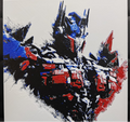 Framed 3D layered art piece featuring a detailed illustration of a powerful sci-fi robot leader character in iconic red and blue armor plating, shown in a dynamic heroic pose against a light background.