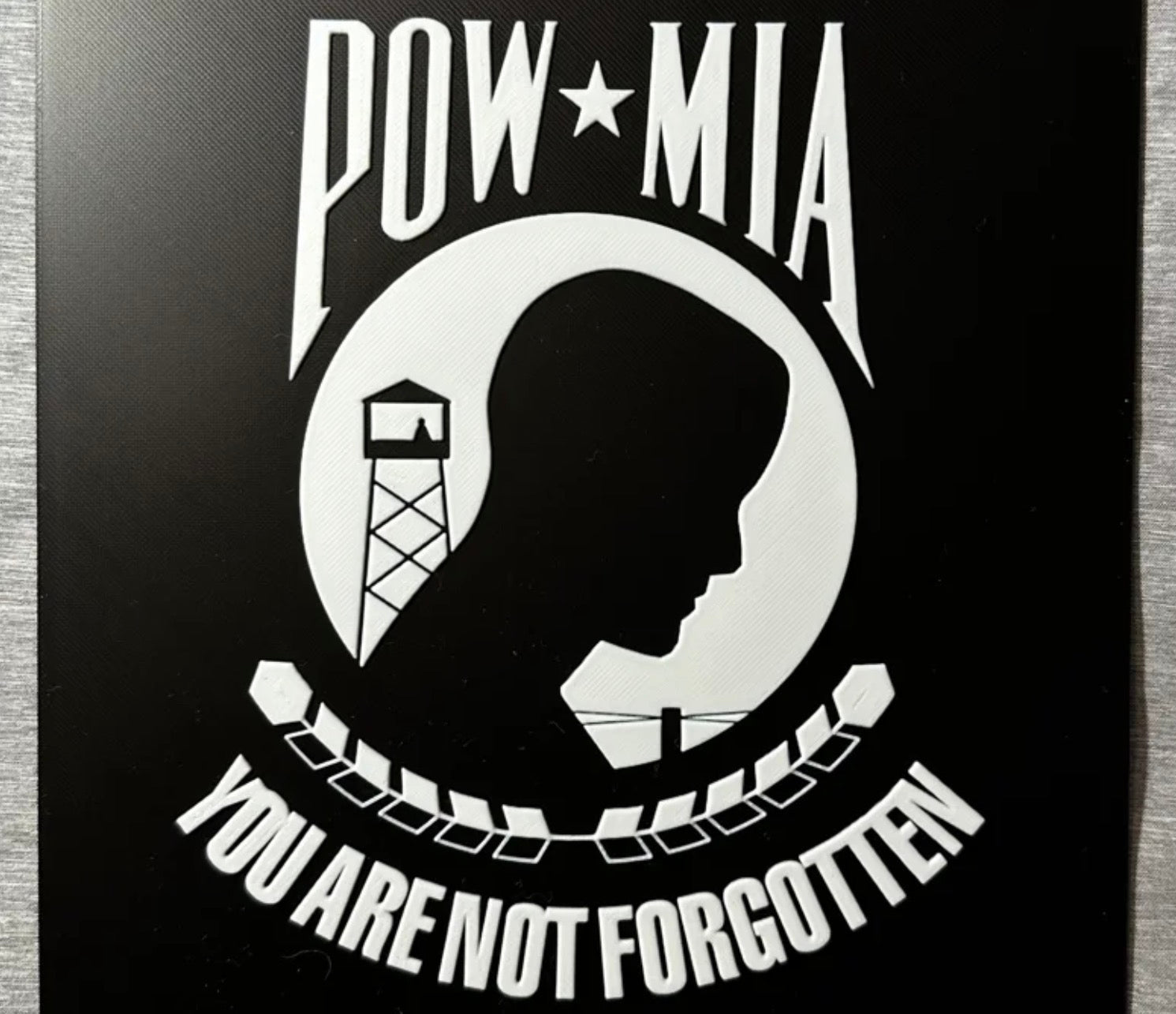 Framed 3D layered art piece featuring the POW/MIA flag in grayscale.