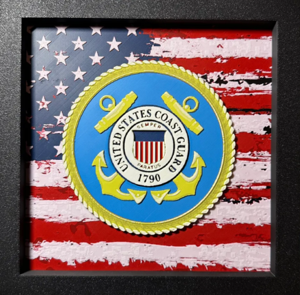 Framed 3D layered art piece featuring U.S. Coast Guard emblem over stylized American flag art in red white and blue