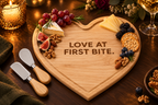 Heart-shaped cheese board engraved 'Love At First Bite.'
